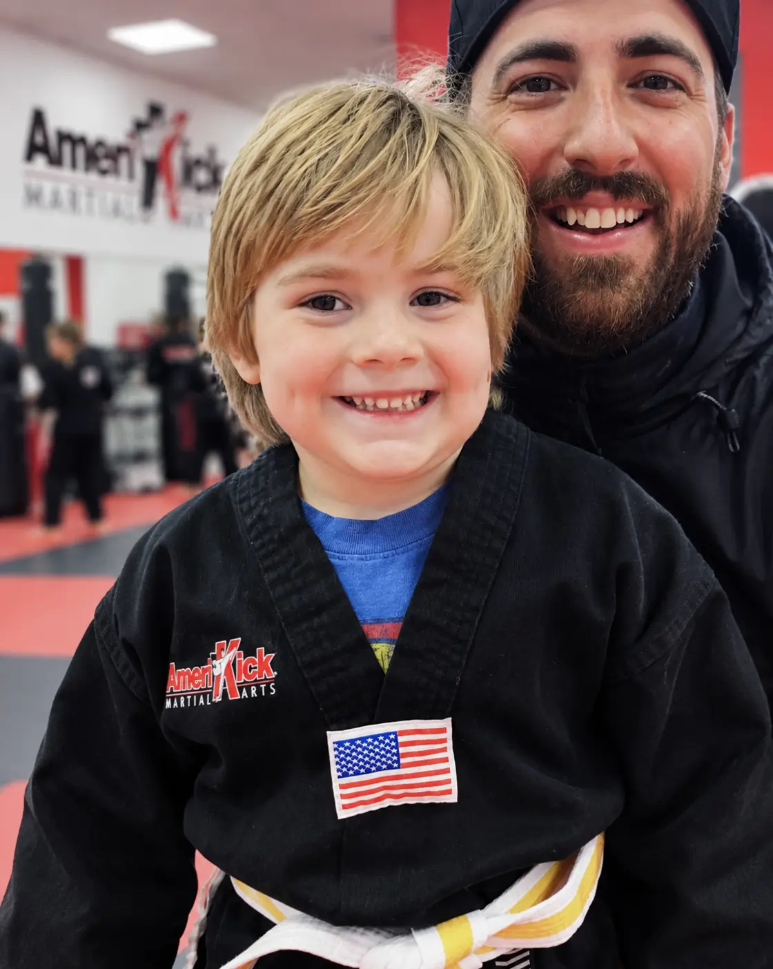A smiling young AmeriKick student with an encouraging instructor
